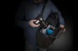 Thule Covert DSLR Rolltop Backpack worn with side access for camera