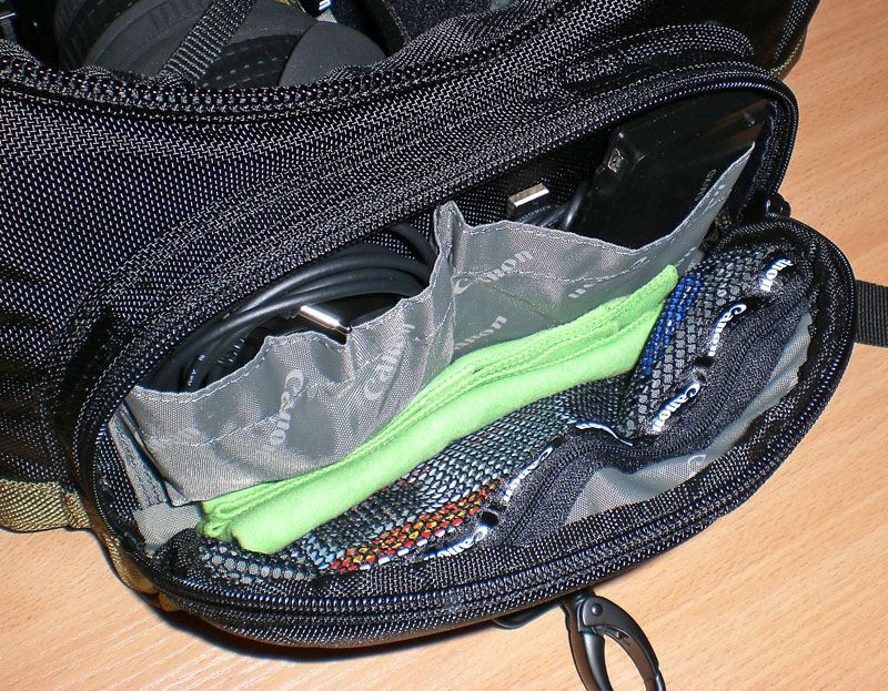 Top Left:Video Cable Top Right: Memory card reader and a USB cable Bottom: Net zip pocket, for carrying flat items, pens, lens cleaners, memory card cases, micro torches, etc.