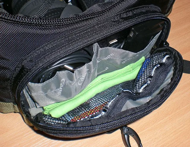 Top Left:Video Cable Top Right: Memory card reader and a USB cable Bottom: Net zip pocket, for carrying flat items, pens, lens cleaners, memory card cases, micro torches, etc.