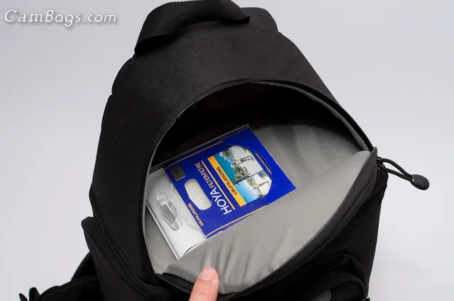he main comparment can fit quite a surprising amount of gear because of its depth. The top compartment is fairly small only allowing small accessories like filters, chargers or lens hoods.