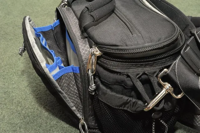 The front of the bag has a zippered pocket that when open can pull far enough away from the bag to be able to see the contents therein completely. This pocket has dividers and slots for pens, cards, batteries, what have you.
