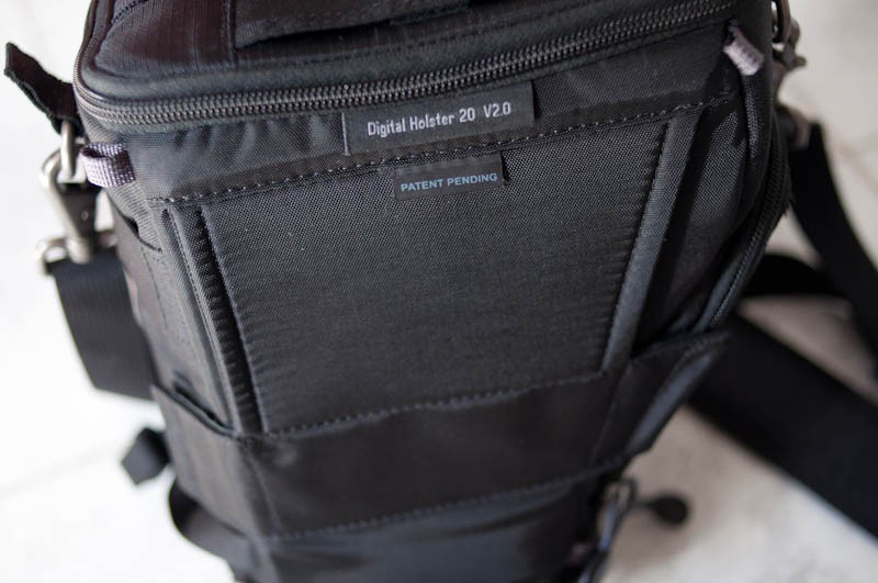 The bag has an attachment for the Think Tank modular belt straps or a normal belt. Unlike some holsters you do have to feed a belt through it before you put this on because of the size of the velcro strip at the bottom.