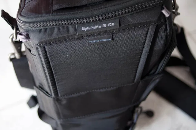 The bag has an attachment for the Think Tank modular belt straps or a normal belt. Unlike some holsters you do have to feed a belt through it before you put this on because of the size of the velcro strip at the bottom.
