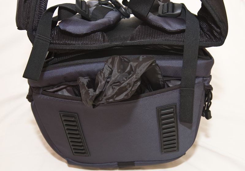 Waterproof cover. I like that its hidden at the bottom of the bag to add protection to the camera gear when the pack is put down.
