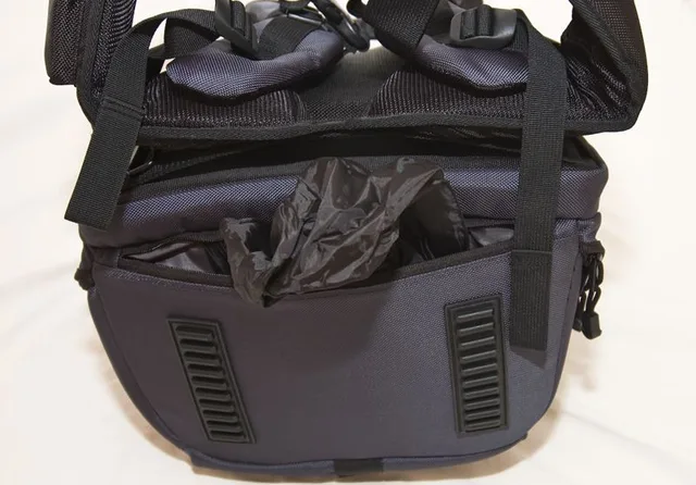Waterproof cover. I like that its hidden at the bottom of the bag to add protection to the camera gear when the pack is put down.